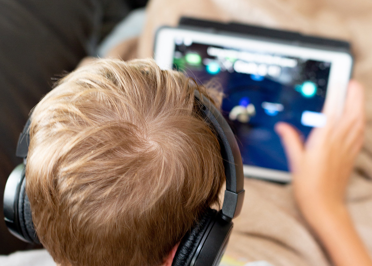 Junge mit Headset am Tablet